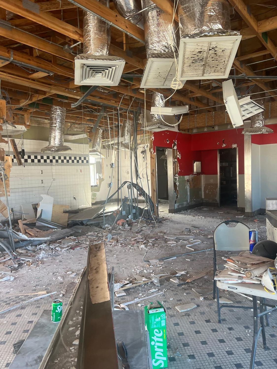 Demolition further along, structure exposed and debris across the floor