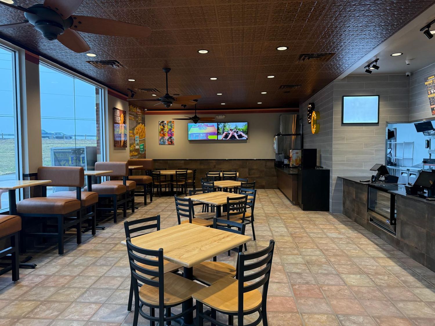 Finished dining area with booth seating, ceiling fans and a window wall