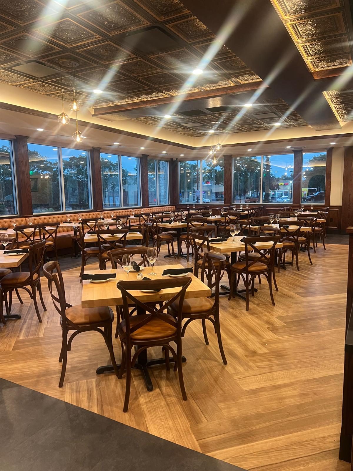 Completed Venezia Trattoria dining room with a pressed tin ceiling, herringbone floor and leather banquette seating